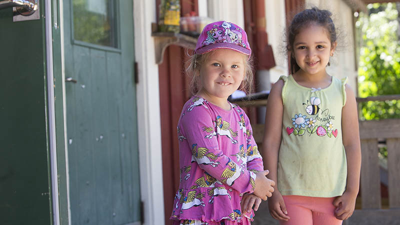 Två flickor tittar in i kameran.