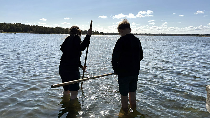 Två barn vadar i vattnet